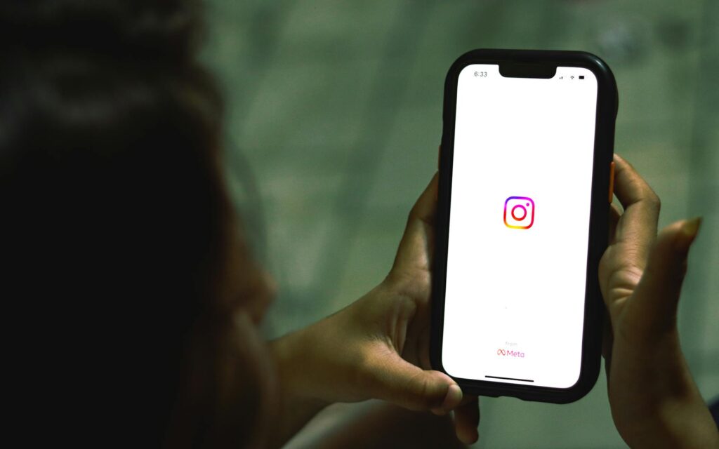 Instagram logo on phone for behind-the-scenes content section